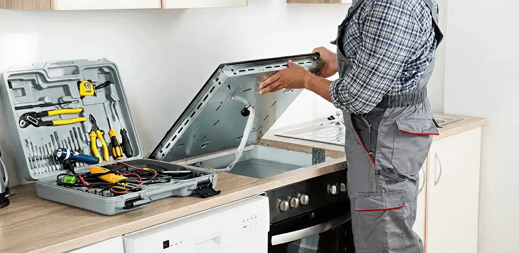 Handyman repairing a cooktop and checking wiring connections in Springfield, MO