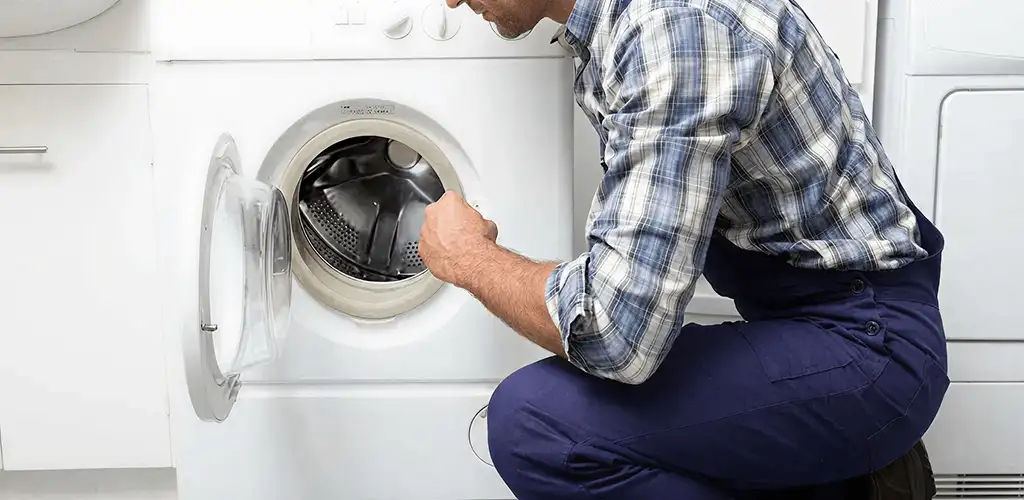 Handyman inspecting a dryer drum and internal parts for repair in Springfield, MO