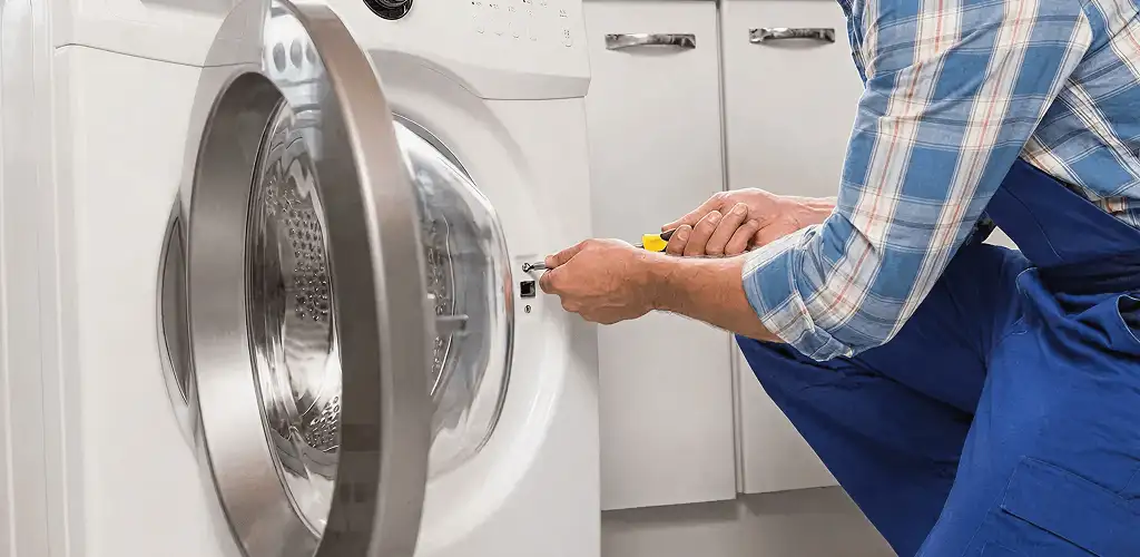 Handyman repairing a clothes dryer and checking electrical connections in Springfield, MO