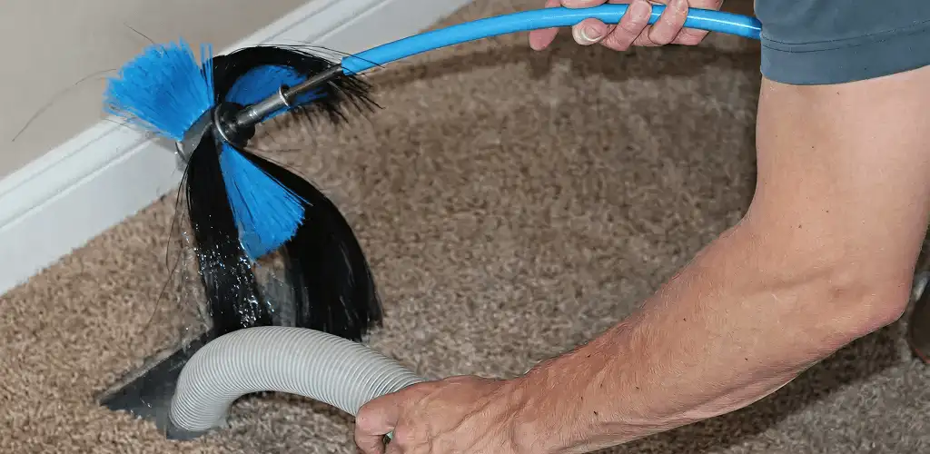 Dryer vent cleaning technician brushing lint from a vent line in Springfield, MO