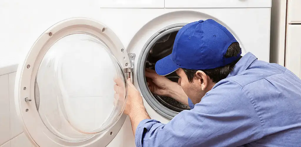 Washing machine repair handyman inspecting a front-load washer drum in Springfield, MO
